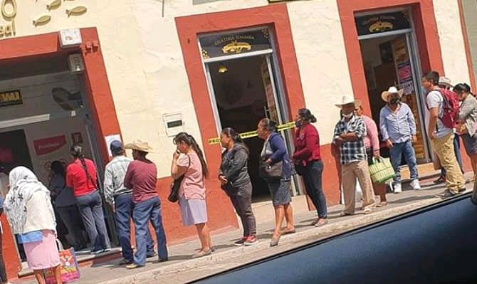 Sin atender la sana distancia, hacen fila en Atlixco para cobrar remesas