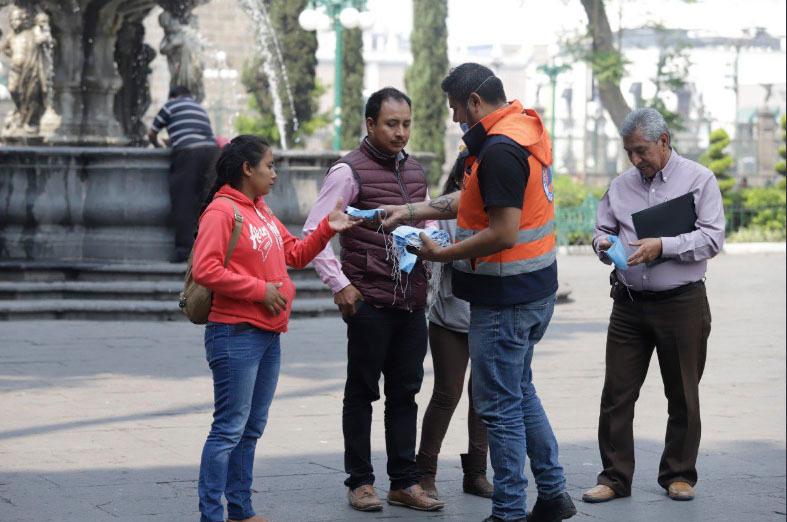 Reparten en zócalo de Puebla cubre bocas ante contaminación  