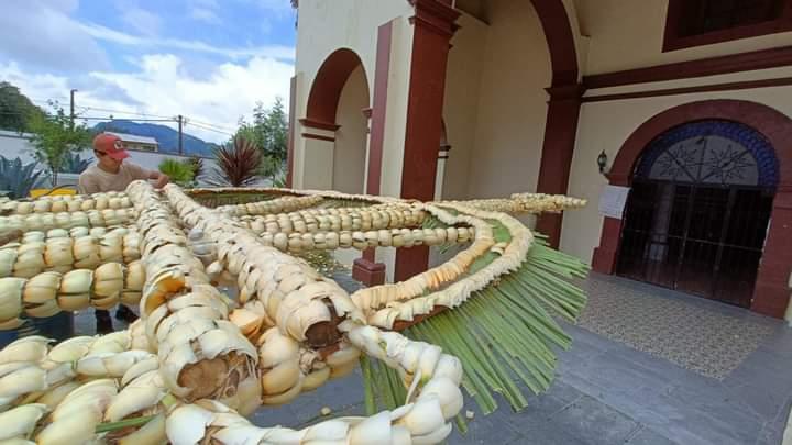 Manos artesanas elaboran el tradicional arco de flor de ximal