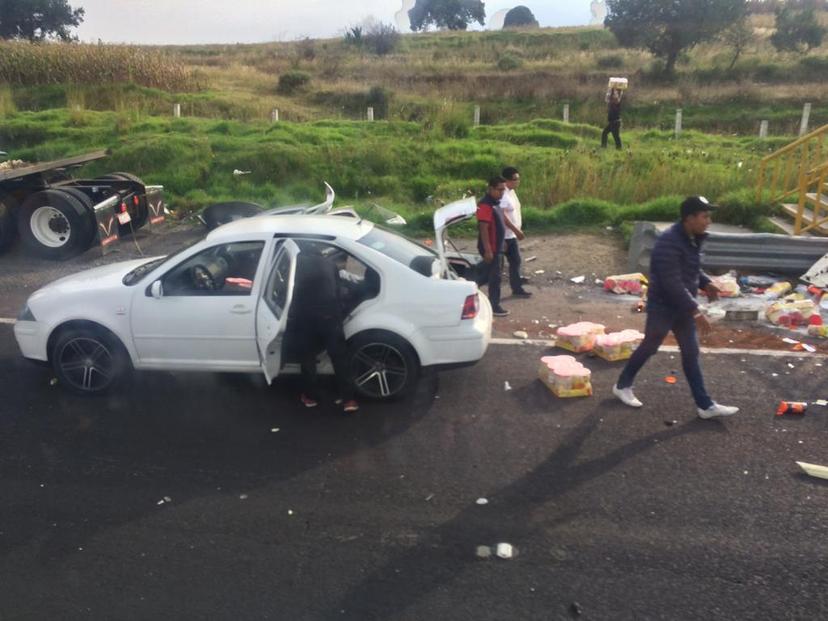 Rapiña de abarrotes tras camión volcado en la México-Puebla