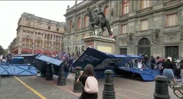 Mujeres en manifestación tiran vallas en Palacio Nacional