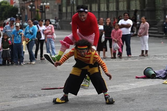 Payasitos y artistas urbanos generan aglomeraciones en el zócalo de Puebla