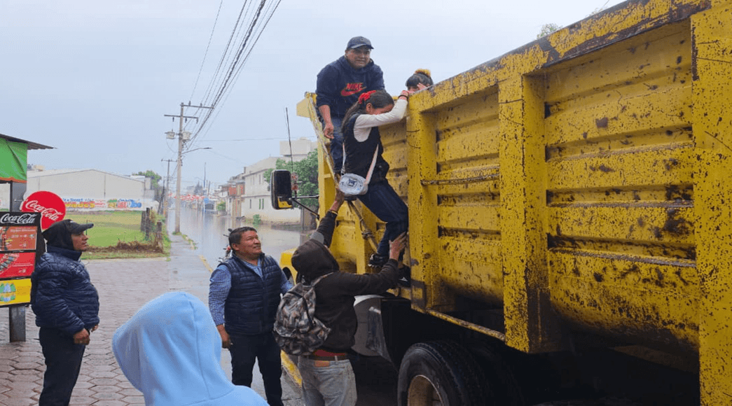 Rescatan a estudiantes de Coronango con camiones de volteo tras fuertes lluvias.