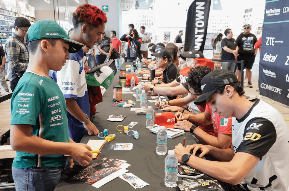 Pilotos de NASCAR México firman autógrafos en Puebla.